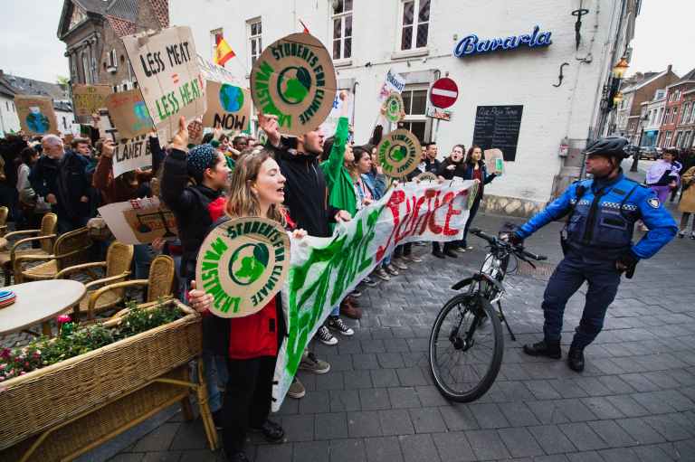 officer standing beside bike and people with signs
